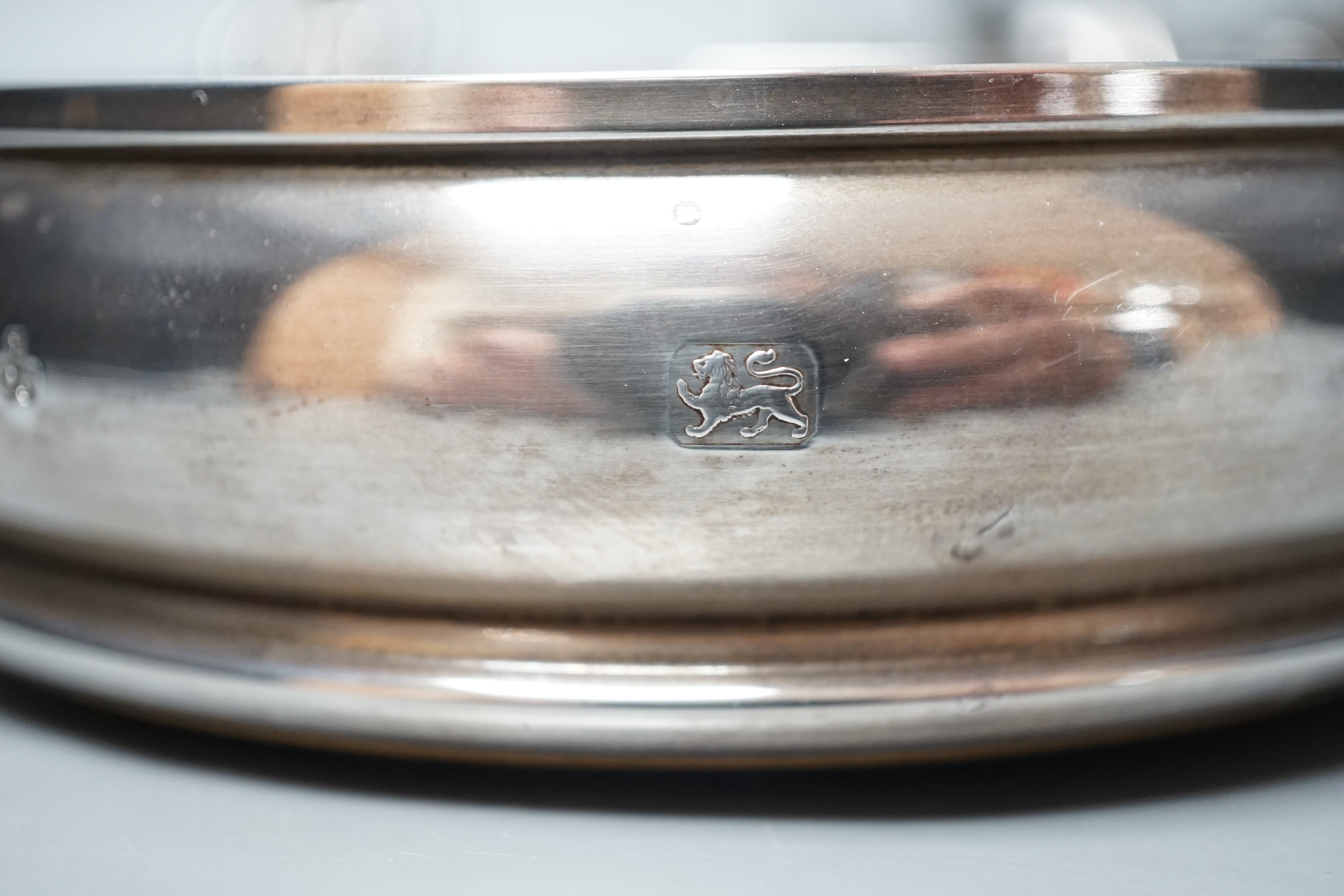 A modern silver mounted wine coaster, London, 1996, diameter 12.4cm, an earlier pierced silver bonbon dish and a pair of plated candlesticks.